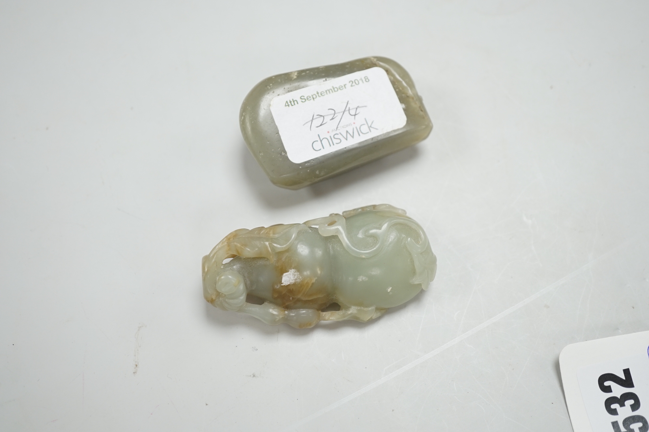 A Chinese green and russet green and brown jade carving of gourd and a green jade pebble carved in relief with a dragon, largest 6.5cm high (2)